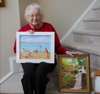 Dorothy displays two of her paintings.