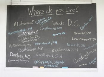 A chalkboard asking where attendees live. Responses include Alabama, Colorado Springs, WAshington, D.C., Columbus, Newark, Cardington, Parkersburg, W.V., Okinama Japan, Georgia, North Carolina, and Virginia.