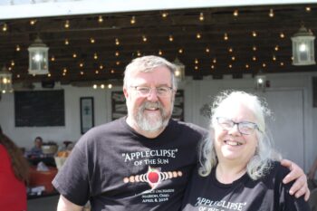 A couple smiles while wearing "Appleclipse" shirts. 