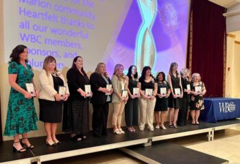 The nominees stand on a stage at the awards ceremony. 