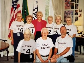 The six Overall sisters, their brother and one of their adult sons pose with Mary Ellen Withrow in her office. 