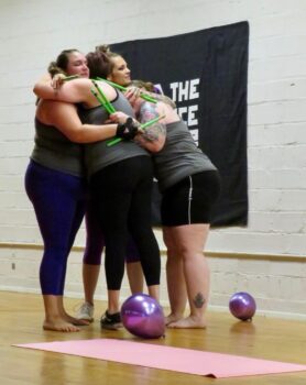 A group of women hug at the fundraiser. 