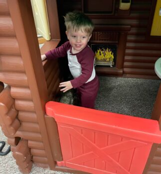 A boy plays inside a play log cabin at the Explore-It-Torium. 