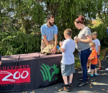 A Columbus Zoo employee shows a crowd a large turtle