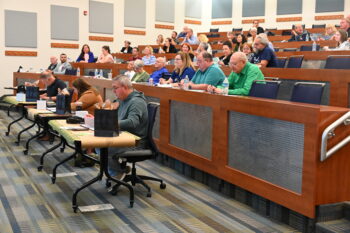 Three judges sit in front of an auditorium during the Forge. 