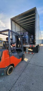 A forklift raises donations from the hurricane relief drive into the back of a semi-truck trailer.