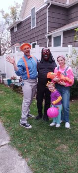 Tommy, his daughter, son-in-law and two grandchildren smile while dressed up for Halloween. 