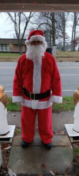 Tommy Mullins dresses as Santa Claus and stands outside this home. 