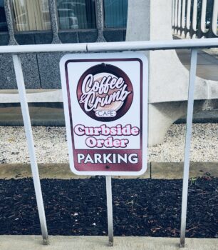 A sign labels a curbside parking spot for pick-up orders.