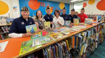 Representatives of the American Legion present a check to smiling librarians for the Imagination Library.